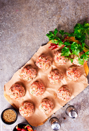 Raw meatball over concrete background ready for cookingの写真素材