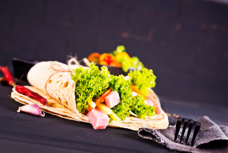 Traditional Middle Eastern snack. Fresh shawarma with ham, pork, cabbage, sauce and pita bread.の写真素材
