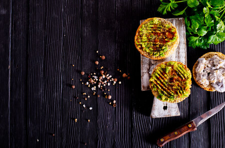 Fresh sandwich with avocado and herbs and seeds on wooden background