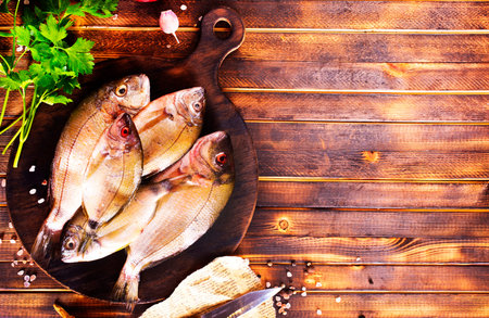 Uncooked Raw fish on board. wooden background. Top view.