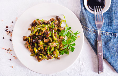 fried eggplant with vegetables and aroma spices on plateの写真素材