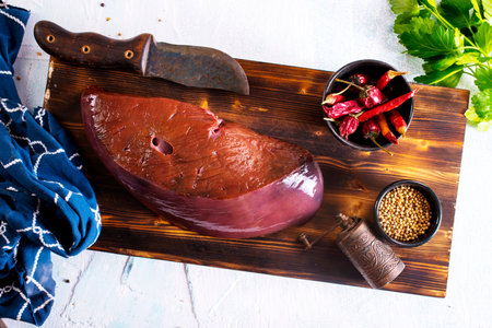 Raw Beef liver meat on wooden cutting boardの写真素材