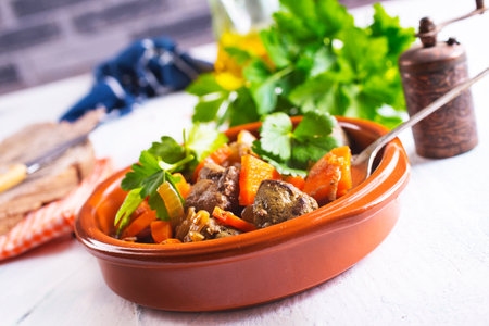 Fried chicken liver with onions and carrots in bowlの写真素材
