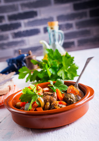 Fried chicken liver with onions and carrots in bowlの写真素材