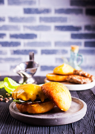 Cheese beef burger with a lettuce. Burger with meat. Junk fast food. Cooking a burger at home.の写真素材