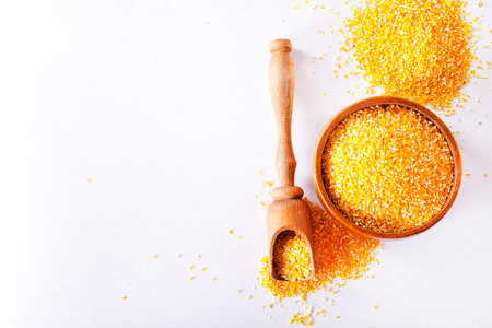Millet in a spoon and wooden bowl with twigs on a table.の写真素材