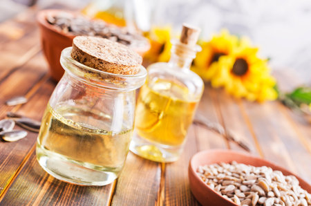 Closeup photo of sunflower oil with seeds on wooden background. Bio and organic product concept.の写真素材