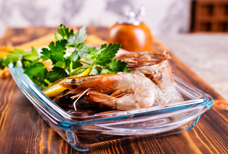Uncooked Raw peeled tiger white shrimp prawn. wooden background. Top view.の写真素材