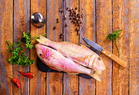 raw fish with spice, wooden background