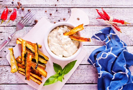 Baked crispy eggplant sticks served with white sauce. Vegetarian healthy dish. Selective focusの写真素材