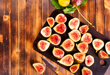 Ripe figs on wooden table, flat lay. Space for text