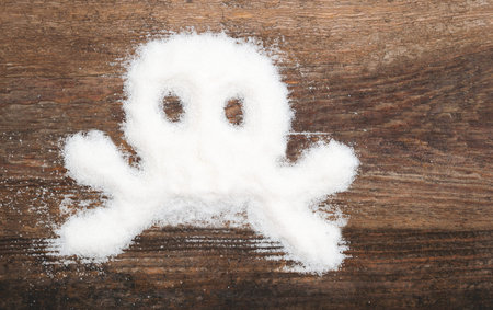 Skull made of granulated sugar. A conceptual photo illustrating the harm from consuming white refined sugar and products containing itの写真素材