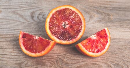 Fresh sliced bloody oranges on a wooden backgroundの写真素材