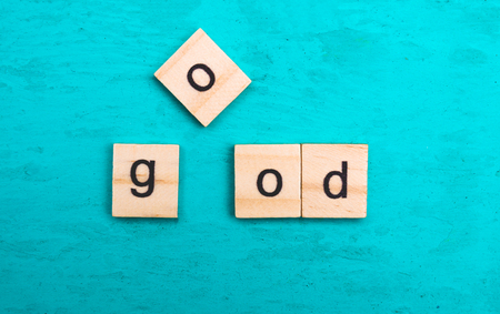 The word "good" laid out with wooden letters of the alphabet on a blue backgroundの写真素材