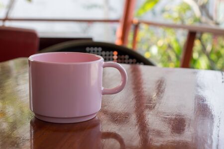 Pink coffee cup Placed on a wooden tableの写真素材