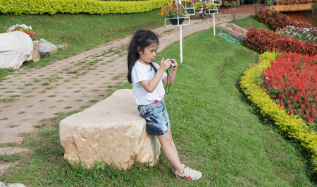 Asian girl with a camera in the garden.の写真素材