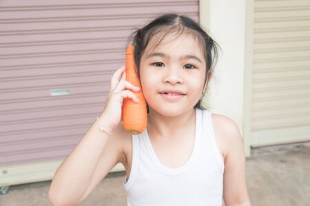Asian happy girl with carrotの写真素材
