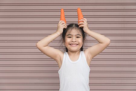 Asian happy girl with carrotの写真素材