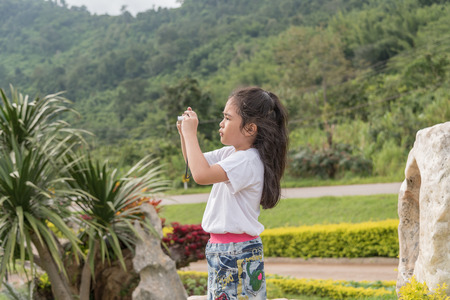 Asian girl with a camera in the garden.の写真素材