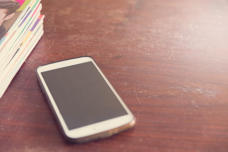 filters vintage smartphone and book on a wooden tableの写真素材
