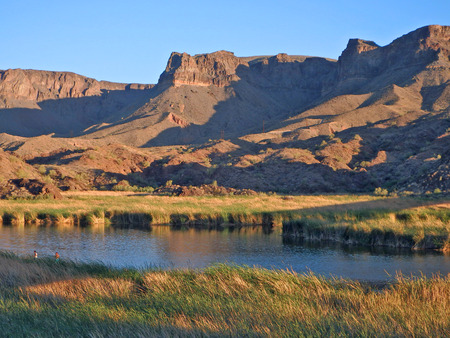Late afternoon sun creates long shadows on mountains in the Bill Williams River National Wildlife Refuge in western Arizona.の写真素材