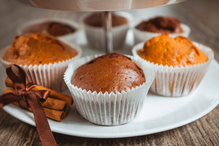 Muffins in paper wrapping. Cinnamon as a decoration.の写真素材