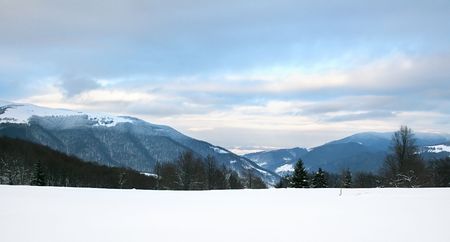 winter landscape with a mountains and a moody skyの写真素材