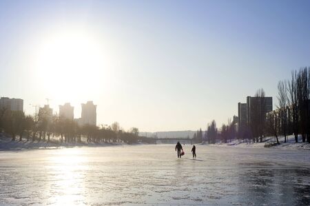 People walking by the Frozen river in the sunshine dayの写真素材