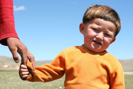 MONGOLIA, AUGUST 06, 2008 - mongolian boy keeping fathers by armのeditorial素材