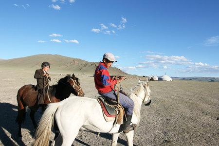 Mongolian boy racing on a horse in front of nomads tent- August 06, 2008. Mongoliaのeditorial素材