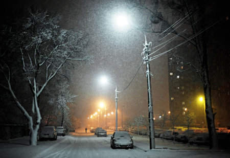 Snow covered cars on the night streetの写真素材