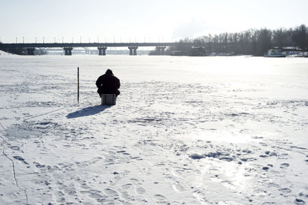 Winter fishing on the river in the sunshine dayの写真素材