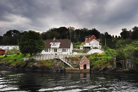 traditional norwegian wooden house standing at the fjords coastの写真素材