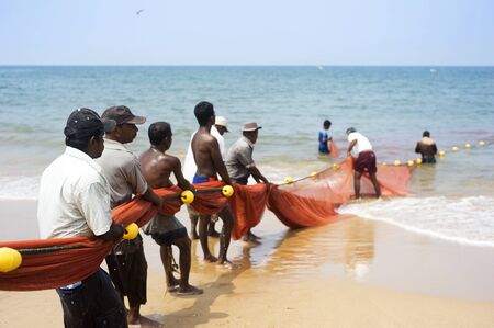Hikkaduwa, Sri Lanka - Feb 19, 2011: Lokal fishermans pulling net from the ocean. Fishing in Sri Lanka is a tough job but this is the way they earn their livingのeditorial素材