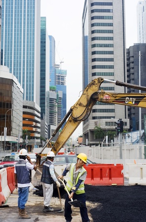 Singapore, Republic of Singapore - May 02, 2011: Workers repairing roads on the one of Singapore city streetのeditorial素材