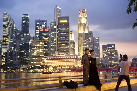 Singapore, Republic of Singapore - May 3, 2011: Photographer take a picture of just a married couple  in front of Singapore business centre - famous place in Singaporeのeditorial素材
