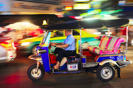 Bangkok, Thailand - March 03, 2013: Tuk - tuk driver riding his tuk-tuk on Chinatown street at night...