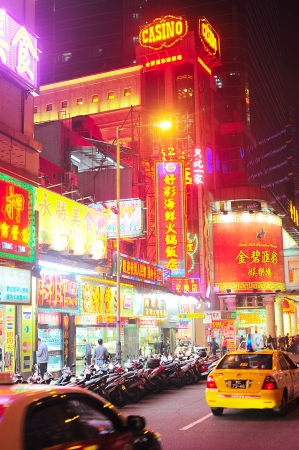 Macau - January 23, 2013: People wlaking on Macau street at the evening. Macau is the gambling capital of Asia and is visited by over 25 million people every year のeditorial素材