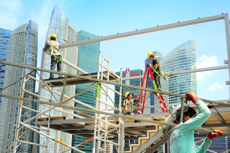 Singapore, Republic of Singapore - May 09, 2013: Workers at construction site in front of Singapore downtown. Construction industry is expected to pull in some S$30 billion this year のeditorial素材