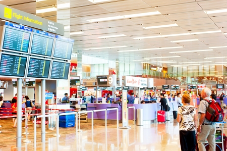Singapore, Republic of Singapore - March 05, 2013: People looking at depature arrival board at Changi International Airport . Changi Airport serves more than 100 airlines operating 6,100 weekly flights connecting Singapore to over 220 citiesのeditorial素材
