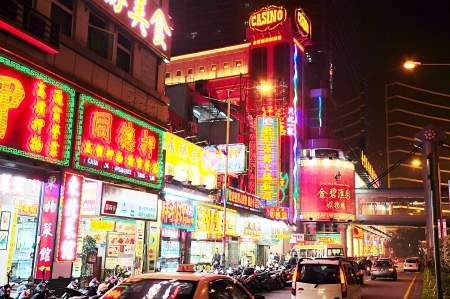 Macau, Macau S.A.R. - January 23, 2013: People walking on Macau street at the evening. Macau is the gambling capital of Asia and is visited by over 25 million people every year のeditorial素材