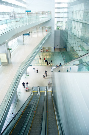 Singapore, Republic of Singapore - March 05, 2013: People at escalators at Changi International Airport. Changi Airport serves more than 100 airlines operating 6,100 weekly flightsのeditorial素材