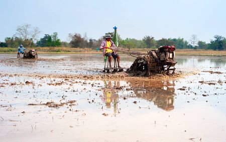 Bangkok, Thailand - March 1, 2013: The tradition farmer use a small machine prepare the soil for planting rice on the farm filed on in Bangkok, Thailandのeditorial素材