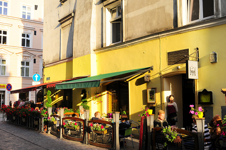 Krakow, Poland - August 27, 2013: Unidentified tourists at a street cafe in old city center of Krakow.  Krakow is cultural capital of Poland have been visited by 8.1 million tourists in 2012.のeditorial素材