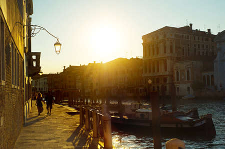Couple walking on quay in the old town of Veniceの写真素材