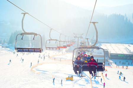 Bukovel, Ukraine - December 13, 2013: Skiers on a ski-lift  in Bukovel. Bukovel - is the largest ski resort in Ukraine. In 2012 it was named the most fast growing world ski resort.のeditorial素材