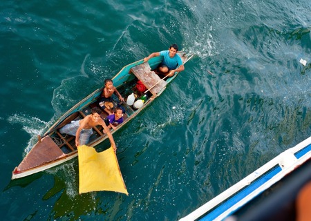 CEBU, PHILIPPINES - MAY 17, 2012: Unidentified beggars asking for a charity in small boat. View from a ship.のeditorial素材