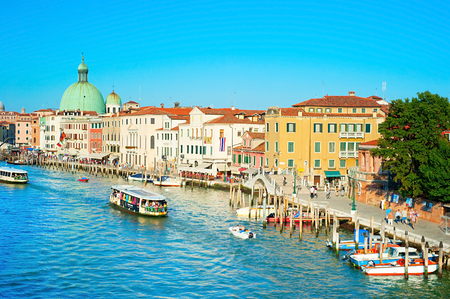 VENICE - SEPTEMBER 5, 2013: People touring the famous Venice Canals on boats and strolling along it in Venice. Currently the city is testing new movable flood barriers.のeditorial素材