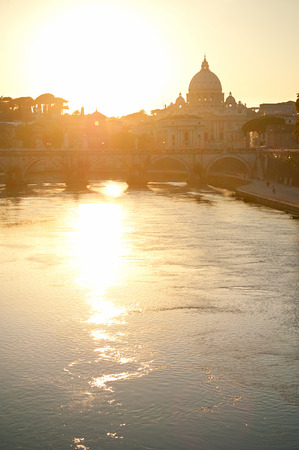 View of Tiber and St. Peter's cathedral at sunset in Romeの写真素材