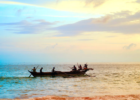 Fisherman on a boat in ocean at sunset, Sri Lankaの写真素材